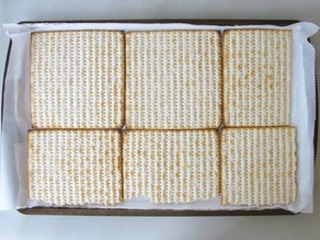 Matzo crackers lining a baking sheet.