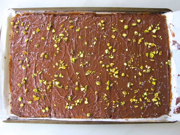 Nuts sprinkled over melted chocolate.