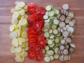 Piles of sliced vegetables on a cutting board.