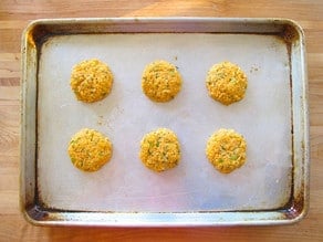 Salmon cakes on a lined baking sheet.