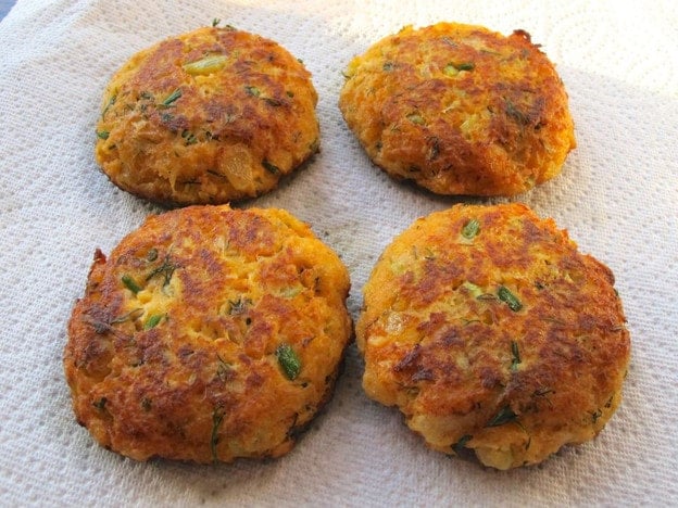 Salmon cakes draining on paper towels.