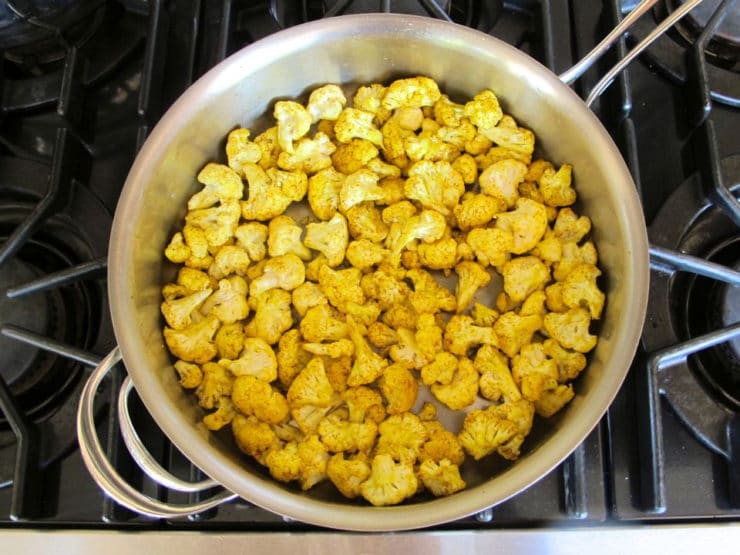 Lightly cooking cauliflower in a skillet.