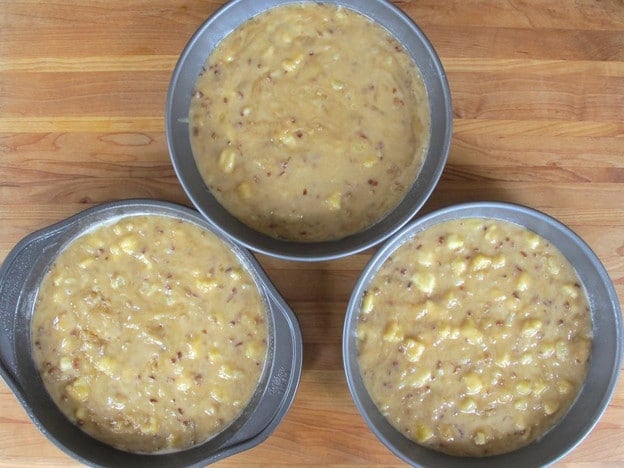 Cake batter divided into three round pans.