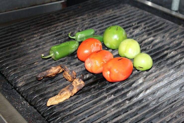 Tomatoes and peppers on a grill.