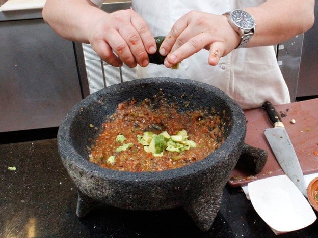 Squeezing limes over salsa.