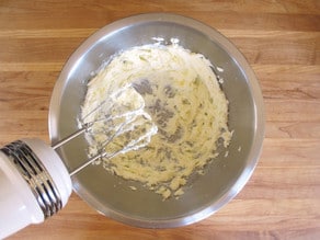 Beating butter in a mixing bowl.