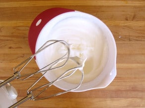 Beating egg whites with a mixer.