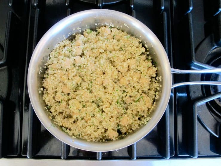 Stirring chickpeas into cooked quinoa.