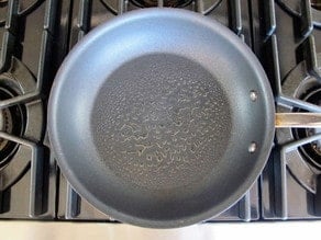 Greasing a preheated nonstick skillet.