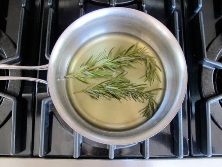 Simmering rosemary simple syrup on the stove.