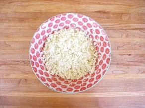 Riced, steamed cauliflower in a bowl.