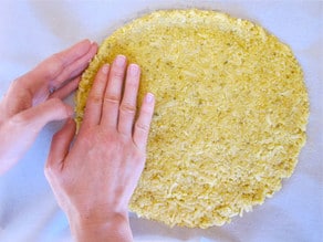 Forming a raised edge around a cauliflower crust.