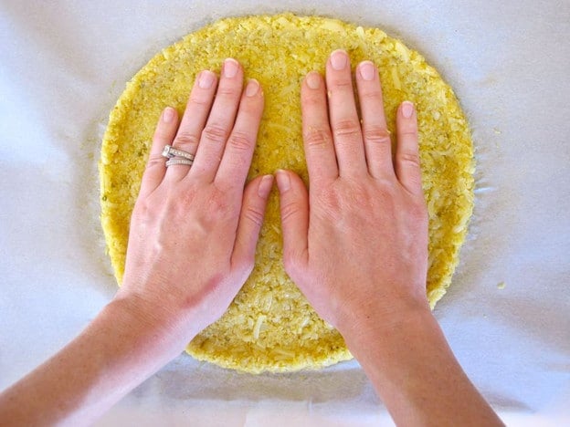 Flattening the inside of a cauliflower crust.