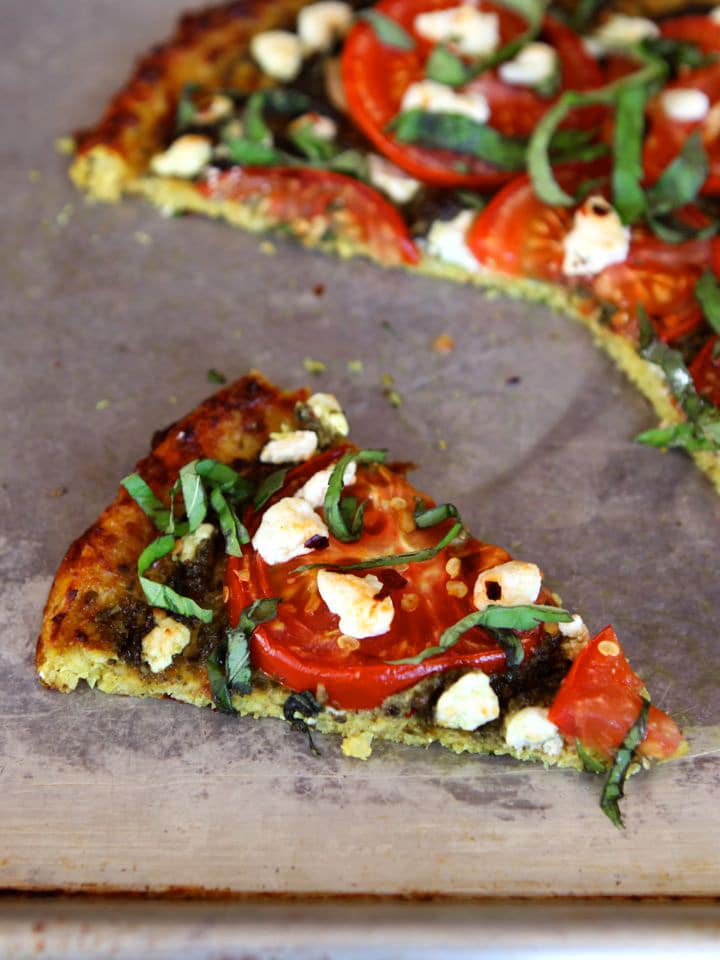 Close up shot of a slice of tomato pesto tart with cauliflower crust.