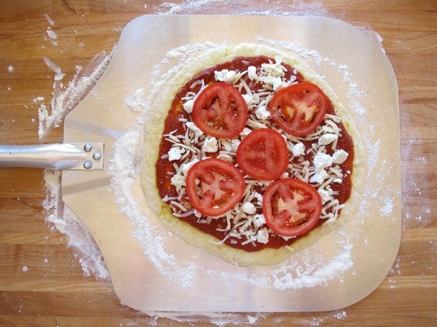 Toppings on pizza, ready for the grill.