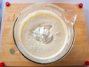 Folding sour cream into cheesecake filling.