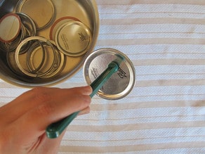 Using a lid lifter on sterilized jar lids.