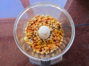 Chickpeas and peanuts with spices in food processor.