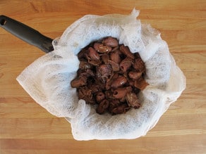 Straining dates in cheesecloth.