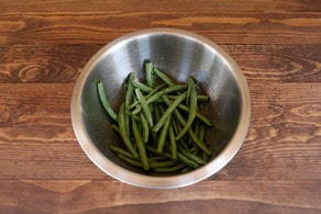 Fresh green beans in a large mixing bowl.