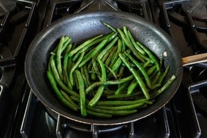 Sauteeing green beans on the stove.