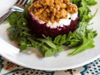 A plate showcasing a salad composed of finely diced roasted beet tartare, accompanied with a fork
