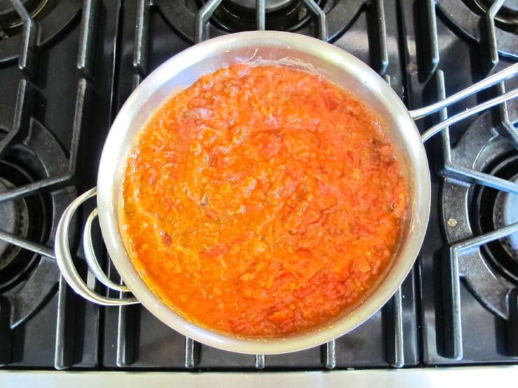 Tomatoes and refried beans in a pan.