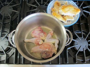 Browning chicken pieces on the stove.