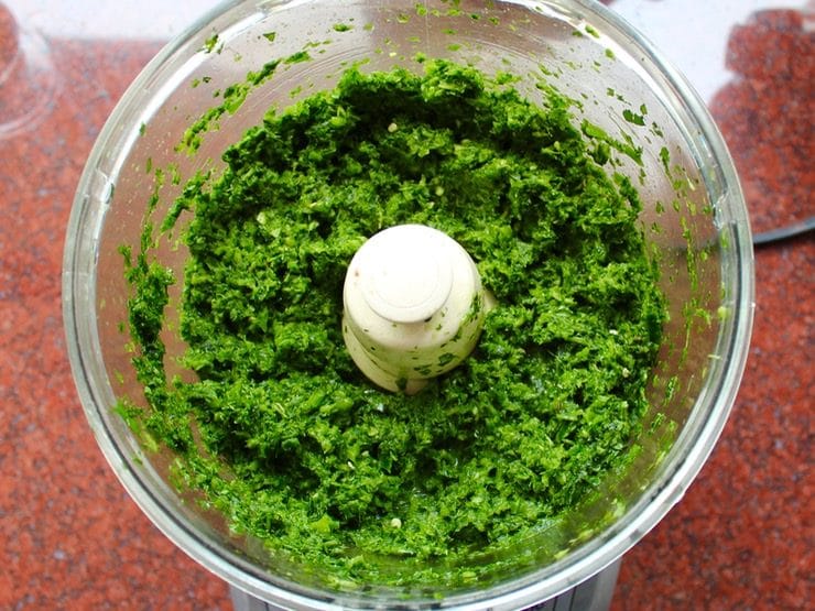 Schug mixture processed to the texture of rough pesto in food processor on kitchen countertop