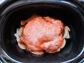 Chicken breast side down in slow cooker.