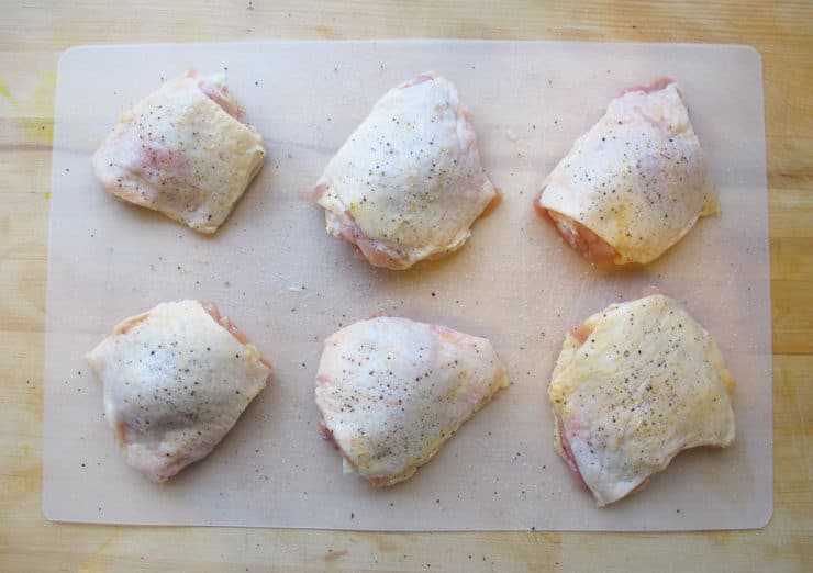 Chicken thighs on cutting board.