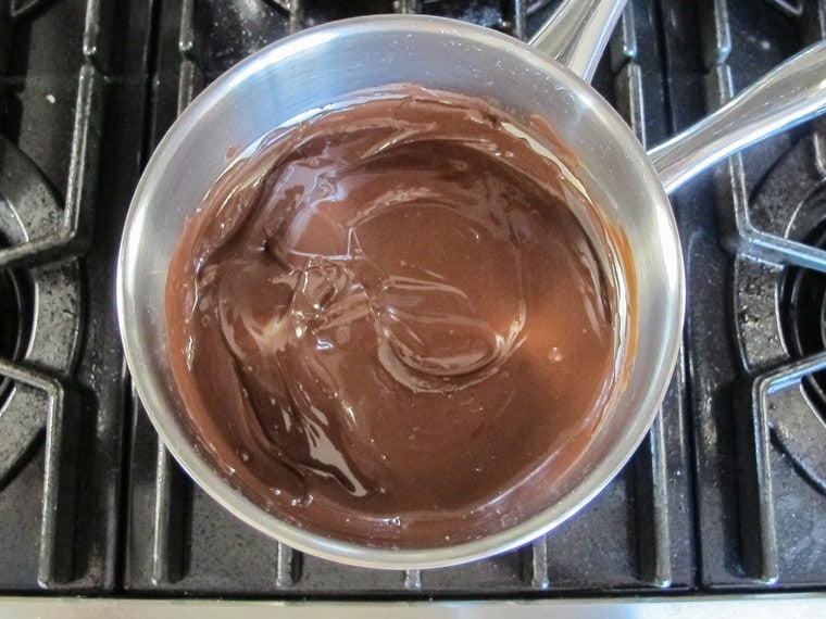 Pan filled with melted dark chocolate on a top of the stove