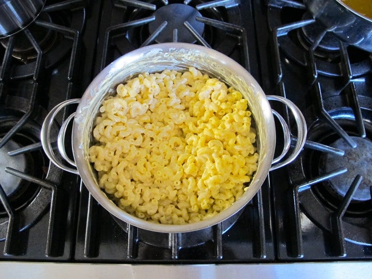 Stirring noodles into cheese sauce.