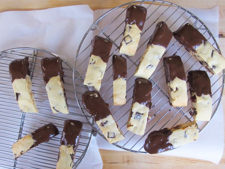 Cherry Mandelbrot have part dipped on a melted chocolate on a cooling rack creating a Dark Chocolate Cherry Mandelbrot