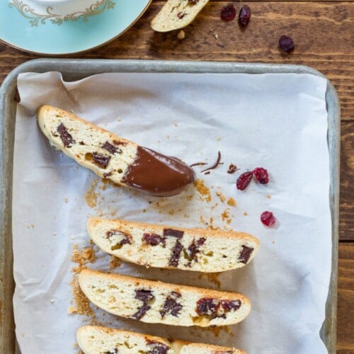 Dark Chocolate Cherry Mandelbrot with one piece semi dipped on a melted chocolate