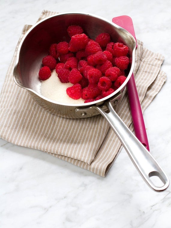 Raspberries and sugar in a saucepan.