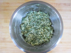 Cottage cheese and spinach in a mixing bowl.