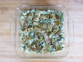 Spinach artchoke filling on matzo in a baking dish.