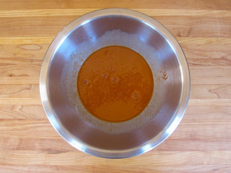 Hot sauce and eggs whisked together in a bowl.