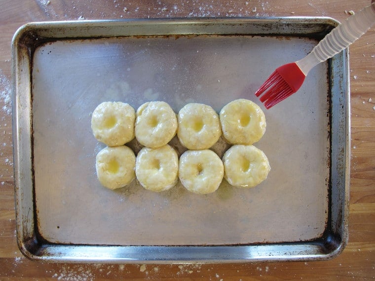 Biscuits on a baking sheet brushed with butter.