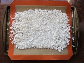 Coconut pulp spread out on a baking sheet.