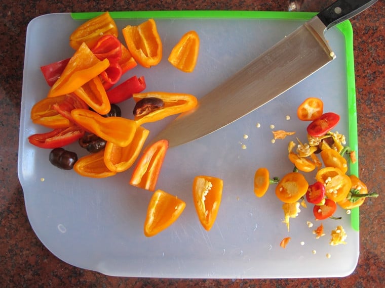 Mini sweet peppers on a cutting board.