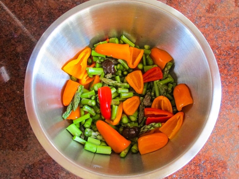 Peppers and asparagus in a mixing bowl.
