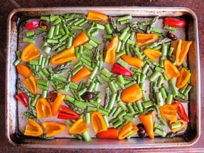 Peppers and asparagus on a baking sheet.