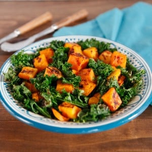 Nutrient-packed sweet potato and kale salad on a plate and a blue napkin