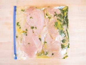 Chicken breasts marinating in a plastic bag.