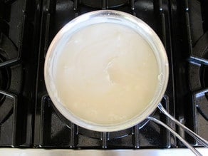 Coconut milk in pan on stove.