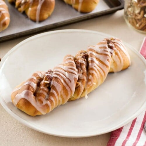 A plate with cinnamon rolls and a fork, including Pecan Rolls, ready to be enjoyed