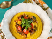 Creamy polenta with Mediterranean vegetables and herbs in a bowl