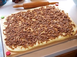 Large dough rectangle covered with pecan filling.